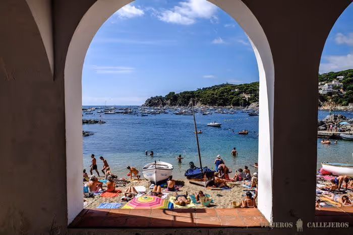 Beach in summer with swimmers and boats in Calella de Palafrugell